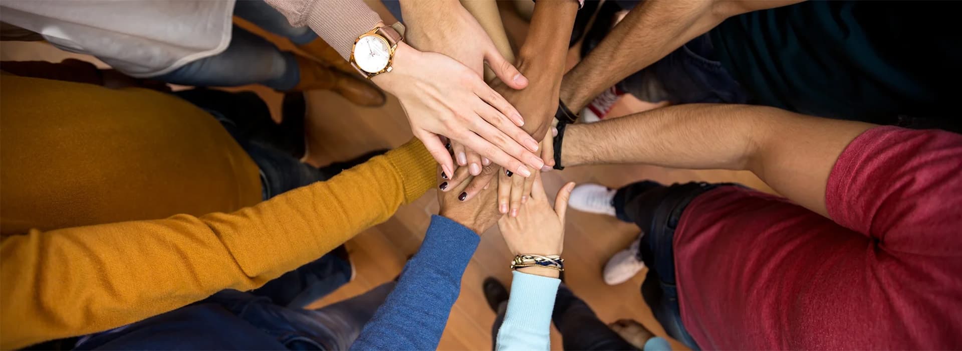 A group of people placing their hands on top of each.